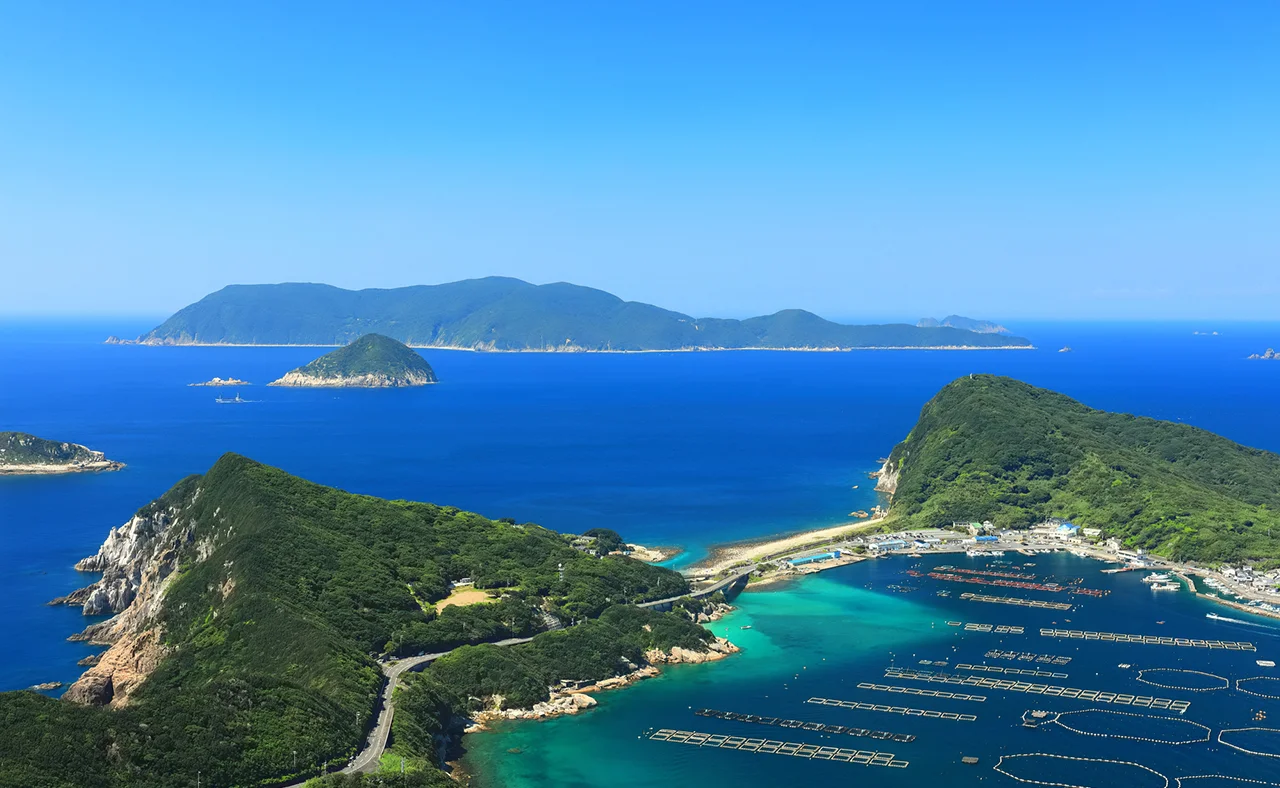 美食島観光ガイドの表紙。海に浮かぶ尼山原島の風景